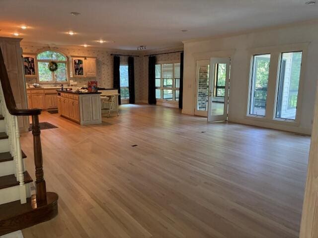 5043 S Glenhaven Ave, Springfield, MO 65804 - unfurnished living room with light wood-style flooring, plenty of natural light, stairs, and recessed lighting