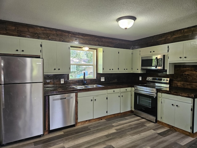 401 Walnut St, Ava, MO 65608 - kitchen with stainless steel appliances, dark countertops, a textured ceiling, dark wood-style floors, and decorative backsplash