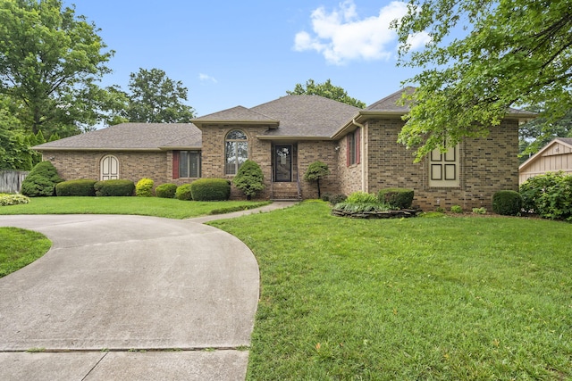 4059 E Linwood St, Springfield, MO 65809 - view of front of home featuring brick siding, a front lawn, curved driveway, and roof with shingles