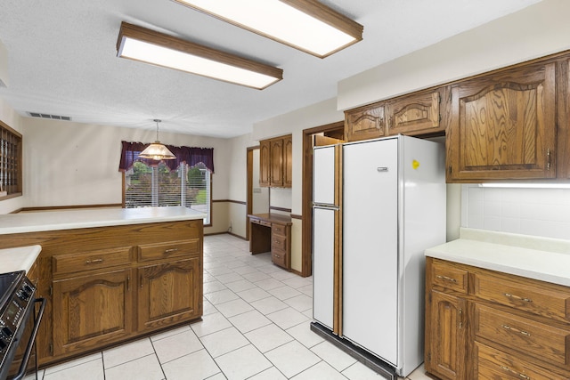 4059 E Linwood St, Springfield, MO 65809 - kitchen with freestanding refrigerator, gas stove, brown cabinetry, and light countertops
