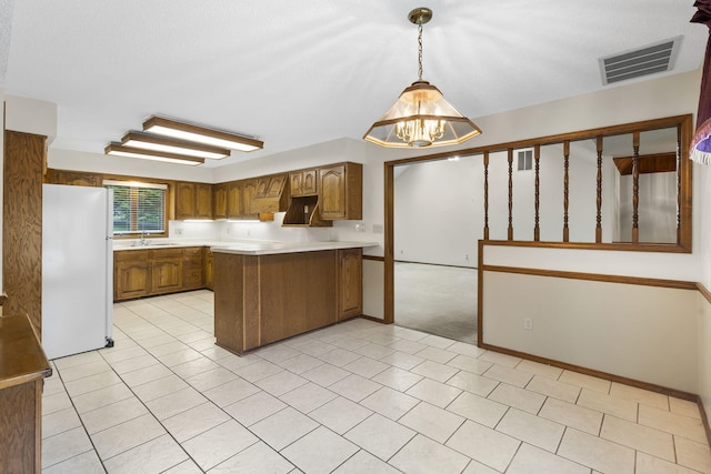 4059 E Linwood St, Springfield, MO 65809 - kitchen featuring freestanding refrigerator, a peninsula, brown cabinets, a chandelier, and light countertops