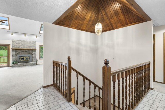 4059 E Linwood St, Springfield, MO 65809 - stairway featuring healthy amount of natural light, track lighting, a brick fireplace, and carpet