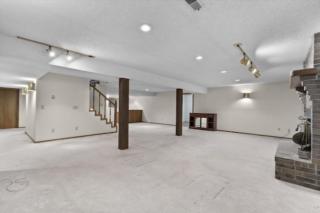 4059 E Linwood St, Springfield, MO 65809 - finished basement featuring rail lighting, a textured ceiling, a brick fireplace, stairs, and recessed lighting