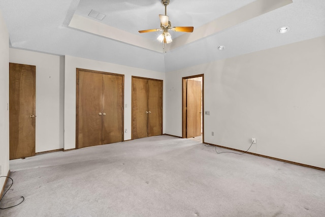 4059 E Linwood St, Springfield, MO 65809 - unfurnished bedroom featuring multiple closets, carpet flooring, ceiling fan, and a tray ceiling