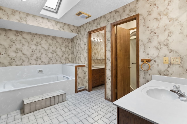 4059 E Linwood St, Springfield, MO 65809 - bathroom with vanity, a skylight, a garden tub, wallpapered walls, and a textured ceiling