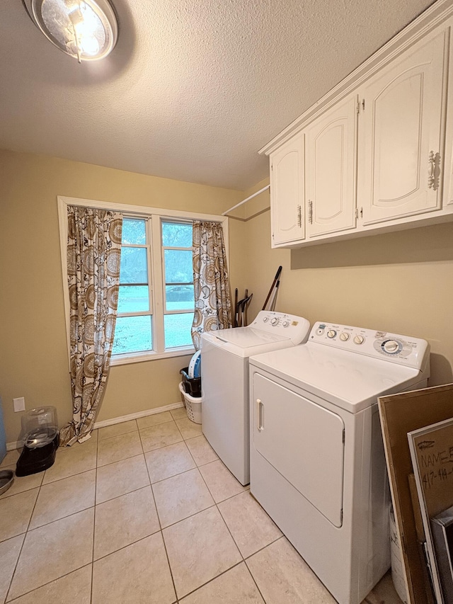 2412 S Camber Ave, Springfield, MO 65809 - laundry room featuring cabinet space, washer and dryer, a textured ceiling, and light tile patterned flooring