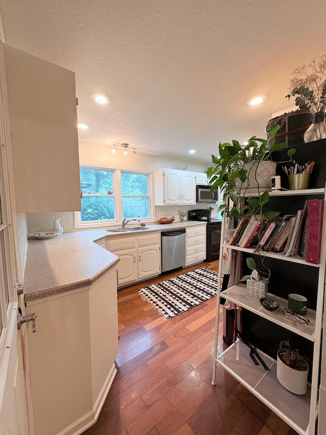 2412 S Camber Ave, Springfield, MO 65809 - kitchen with stainless steel appliances, recessed lighting, a textured ceiling, light countertops, and wood finished floors