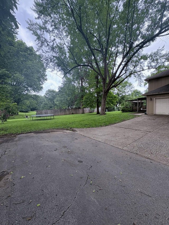 2412 S Camber Ave, Springfield, MO 65809 - view of yard with a trampoline, concrete driveway, and a garage