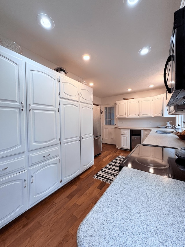 2412 S Camber Ave, Springfield, MO 65809 - kitchen featuring black microwave, freestanding refrigerator, white cabinets, dark wood-style flooring, and recessed lighting