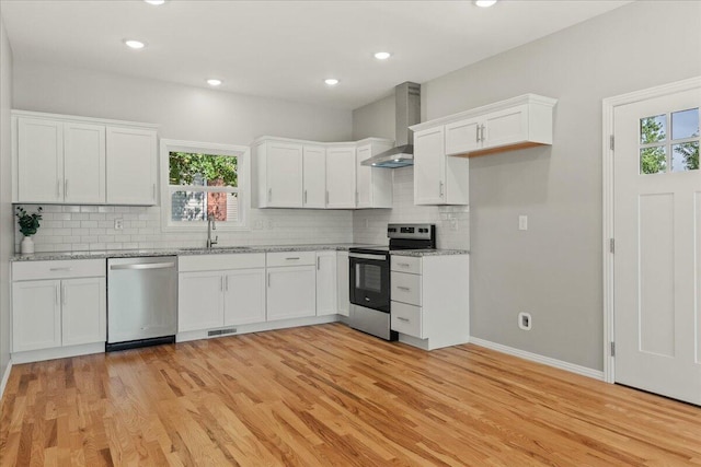 3001 E Colonial Ct, Republic, MO 65738 - kitchen with stainless steel appliances, wall chimney exhaust hood, white cabinetry, light wood finished floors, and recessed lighting