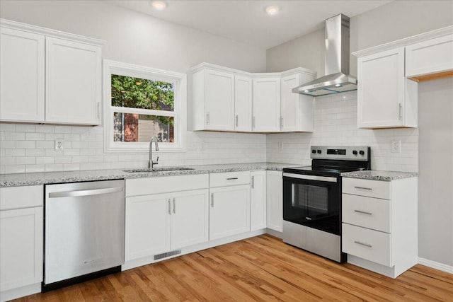 3001 E Colonial Ct, Republic, MO 65738 - kitchen with stainless steel appliances, wall chimney exhaust hood, white cabinets, light stone counters, and recessed lighting