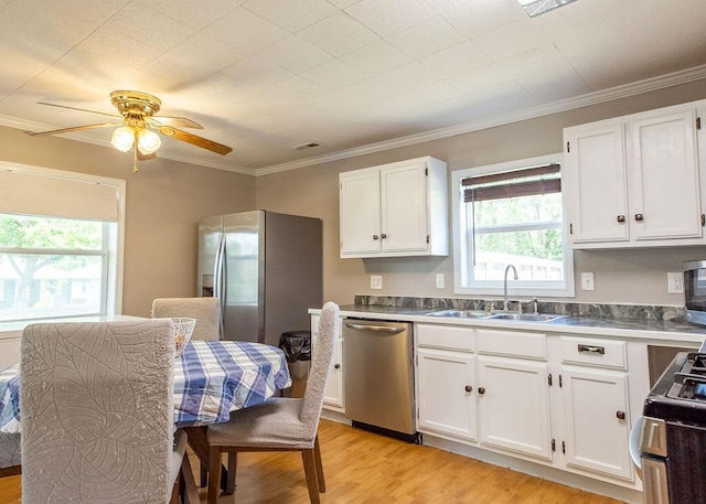 1050 S Glenn Ave, Springfield, MO 65802 - kitchen featuring stainless steel appliances, healthy amount of natural light, white cabinets, and ornamental molding