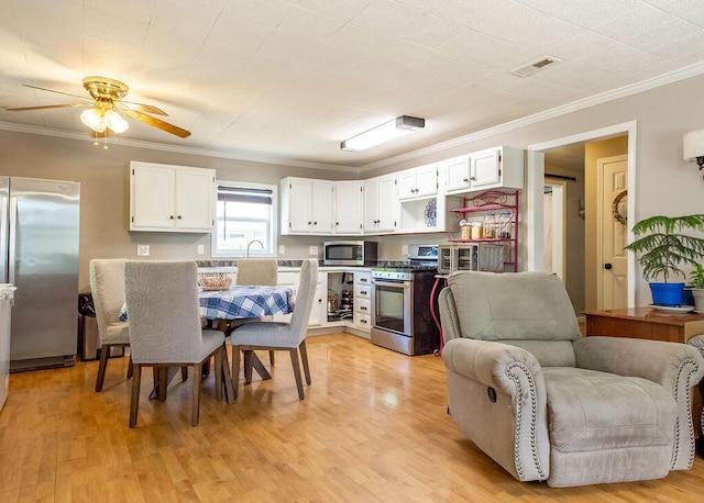 1050 S Glenn Ave, Springfield, MO 65802 - kitchen featuring appliances with stainless steel finishes, ornamental molding, white cabinets, a ceiling fan, and open floor plan