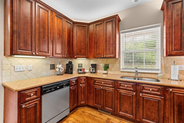 128 Mulligan Ct, Branson, MO 65616 - kitchen featuring stainless steel dishwasher, light wood-type flooring, light stone counters, tasteful backsplash, and reddish brown cabinets