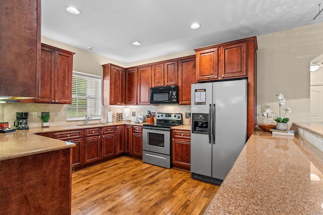128 Mulligan Ct, Branson, MO 65616 - kitchen featuring stainless steel appliances, light wood-style flooring, backsplash, recessed lighting, and light stone countertops