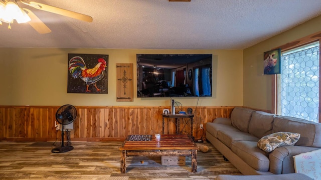 12 Riverbend Rd, Mammoth Spring, AR 72554 - living room with wood finished floors, wainscoting, ceiling fan, a textured ceiling, and wood walls
