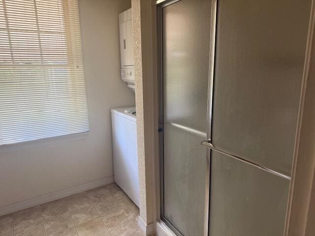 1205 W Main St, West Plains, MO 65775 - laundry room featuring stacked washer and clothes dryer and light tile patterned floors