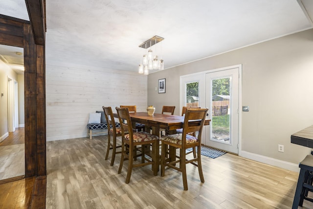 3430 S Elmview Ave, Springfield, MO 65804 - dining room with light wood-style floors, a chandelier, crown molding, wooden walls, and french doors