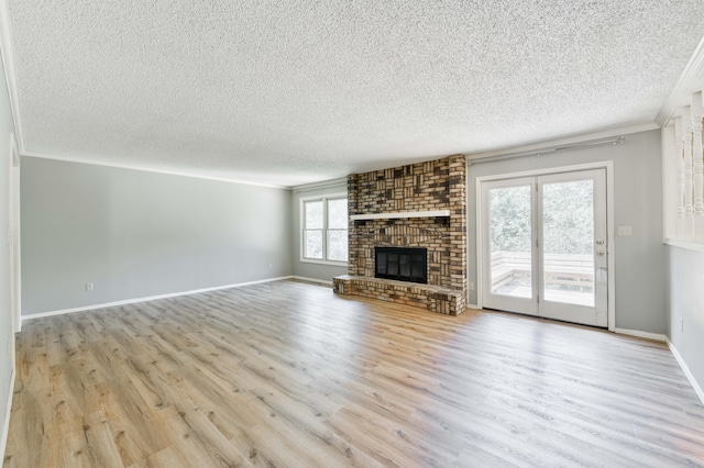 5751 S Kings Ave, Springfield, MO 65810 - unfurnished living room featuring wood finished floors, a textured ceiling, crown molding, and a brick fireplace