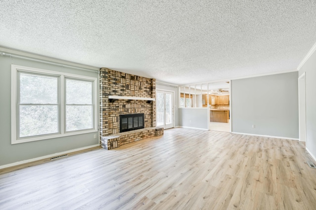 5751 S Kings Ave, Springfield, MO 65810 - unfurnished living room with a textured ceiling, wood finished floors, healthy amount of natural light, a fireplace, and ornamental molding