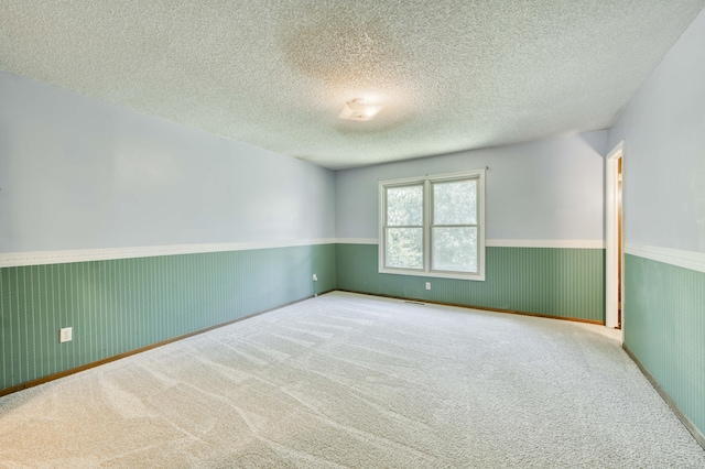 5751 S Kings Ave, Springfield, MO 65810 - empty room featuring a wainscoted wall, carpet flooring, and a textured ceiling
