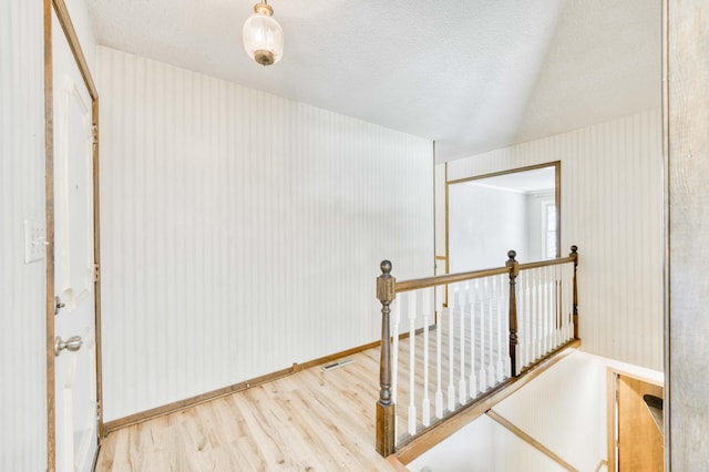 5751 S Kings Ave, Springfield, MO 65810 - hallway with an upstairs landing, wood finished floors, and a textured ceiling