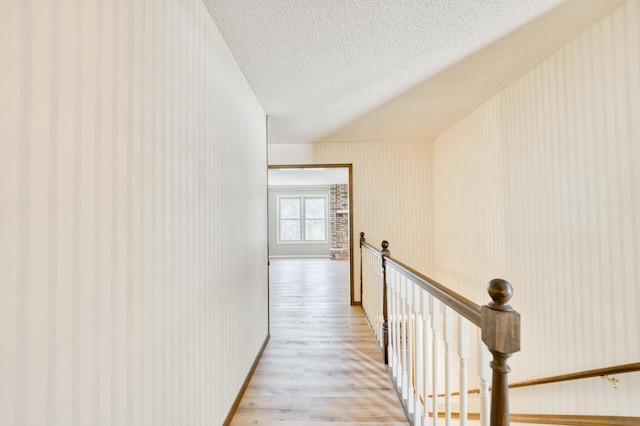 5751 S Kings Ave, Springfield, MO 65810 - corridor with an upstairs landing, light wood-type flooring, and a textured ceiling
