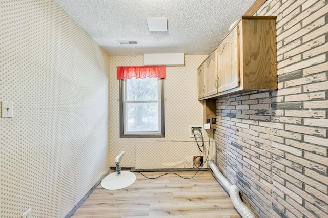 5751 S Kings Ave, Springfield, MO 65810 - laundry room featuring light wood-type flooring, a textured ceiling, and washer hookup