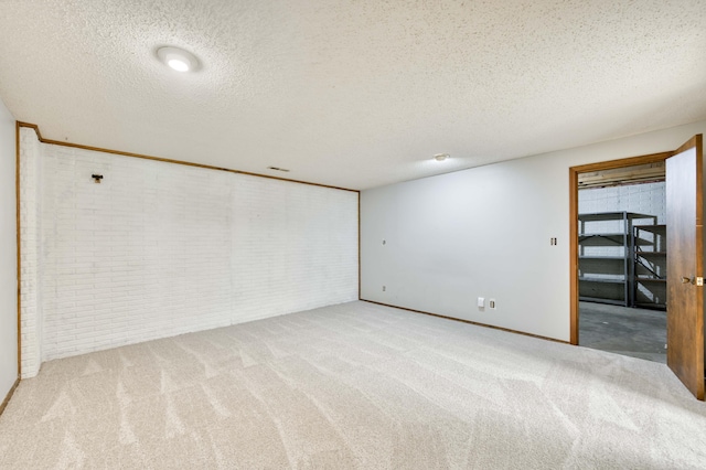 5751 S Kings Ave, Springfield, MO 65810 - below grade area with brick wall, a textured ceiling, and carpet flooring