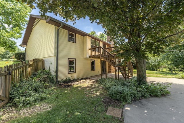 5751 S Kings Ave, Springfield, MO 65810 - view of property exterior featuring stairs, a wooden deck, a patio, a chimney, and brick siding