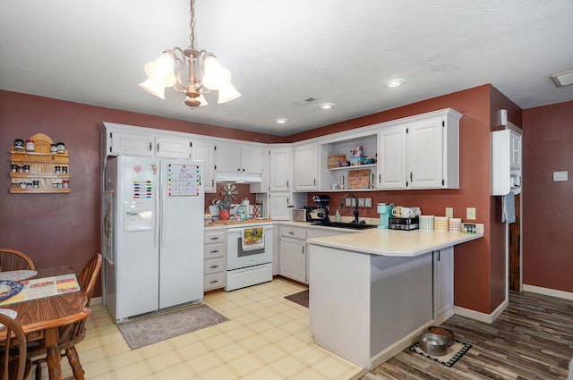 1360 Johnson Rd, Sparta, MO 65753 - kitchen with white appliances, a chandelier, under cabinet range hood, open shelves, and a peninsula