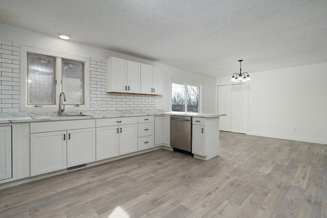502 S Walnut St, Walnut Grove, MO 65770 - kitchen featuring dishwasher, a textured ceiling, a chandelier, a peninsula, and white cabinets