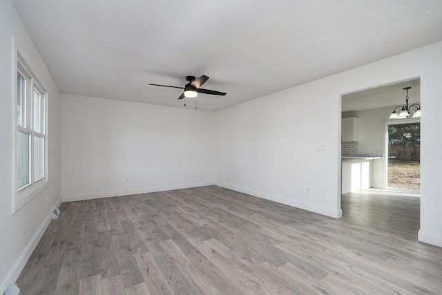 502 S Walnut St, Walnut Grove, MO 65770 - spare room with wood finished floors, a chandelier, a ceiling fan, healthy amount of natural light, and a textured ceiling