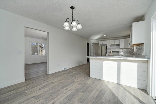 502 S Walnut St, Walnut Grove, MO 65770 - kitchen featuring freestanding refrigerator, electric stove, light countertops, a textured ceiling, and decorative backsplash