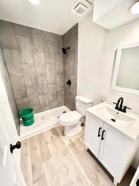900 N Eagle Ave, Springfield, MO 65802 - full bathroom featuring vanity, wood finished floors, and a tile shower