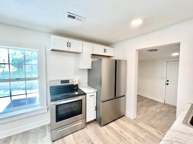 900 N Eagle Ave, Springfield, MO 65802 - kitchen featuring stainless steel appliances, white cabinetry, light wood-style flooring, and light stone counters