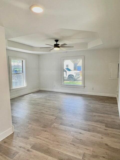900 N Eagle Ave, Springfield, MO 65802 - spare room featuring a tray ceiling, wood finished floors, and ceiling fan