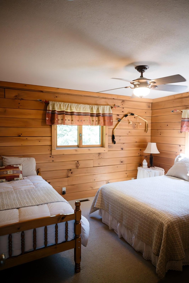 20816 Valley View Trl, Wheatland, MO 65779 - carpeted bedroom featuring wooden walls, a textured ceiling, and a ceiling fan