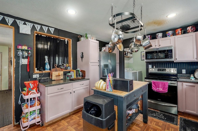 528 N Locust St, Marshfield, MO 65706 - kitchen with appliances with stainless steel finishes, washing machine and dryer, recessed lighting, white cabinetry, and a textured ceiling