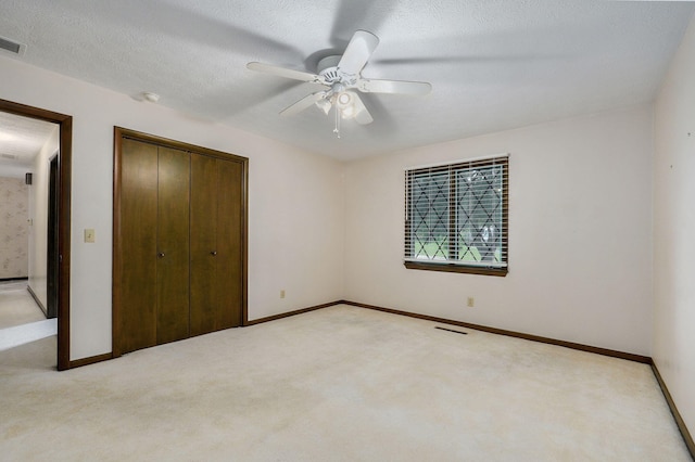 3520 E Carol Dr, Springfield, MO 65809 - unfurnished bedroom with a closet, light colored carpet, ceiling fan, and a textured ceiling