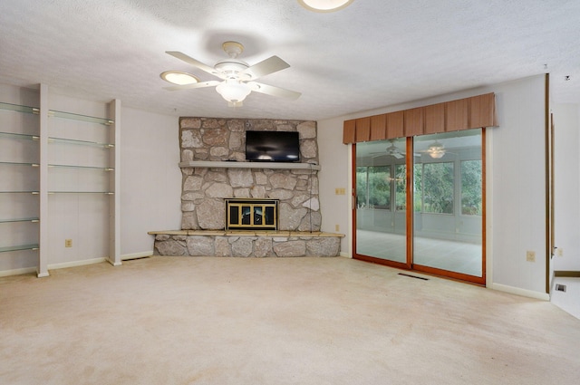 3520 E Carol Dr, Springfield, MO 65809 - unfurnished living room featuring ceiling fan, carpet floors, a stone fireplace, and a textured ceiling