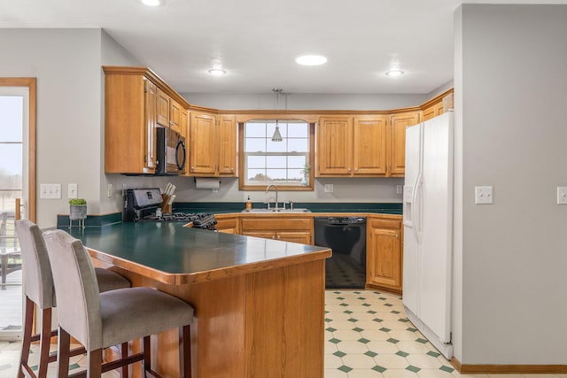2131 Redoak Rd, Fordland, MO 65652 - kitchen featuring black appliances, a peninsula, light flooring, a breakfast bar area, and recessed lighting