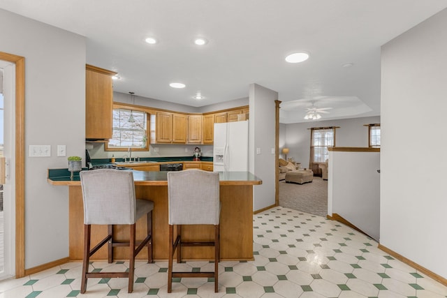 2131 Redoak Rd, Fordland, MO 65652 - kitchen with white fridge with ice dispenser, ceiling fan, a peninsula, dishwasher, and a breakfast bar area