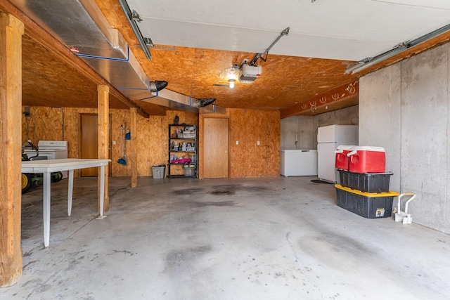 2131 Redoak Rd, Fordland, MO 65652 - garage featuring freestanding refrigerator, a garage door opener, refrigerator, and washer / clothes dryer