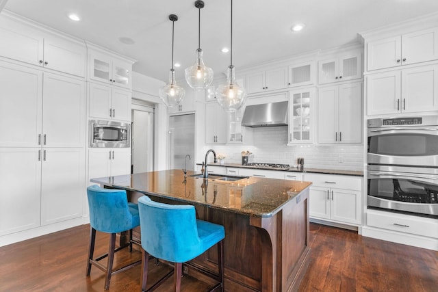 6421 S Valley Brook Ct, Springfield, MO 65810 - kitchen featuring wall chimney range hood, built in appliances, dark wood-style flooring, recessed lighting, and decorative backsplash