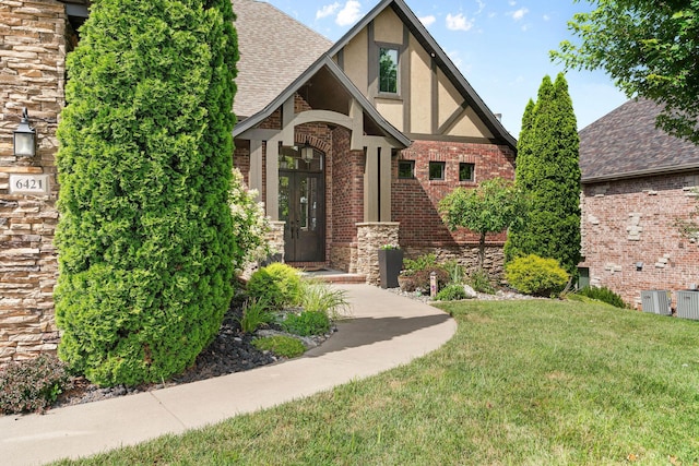 6421 S Valley Brook Ct, Springfield, MO 65810 - english style home featuring stucco siding, a front lawn, brick siding, and a shingled roof