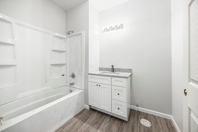 full bath featuring wood finished floors, vanity, and shower / tub combination