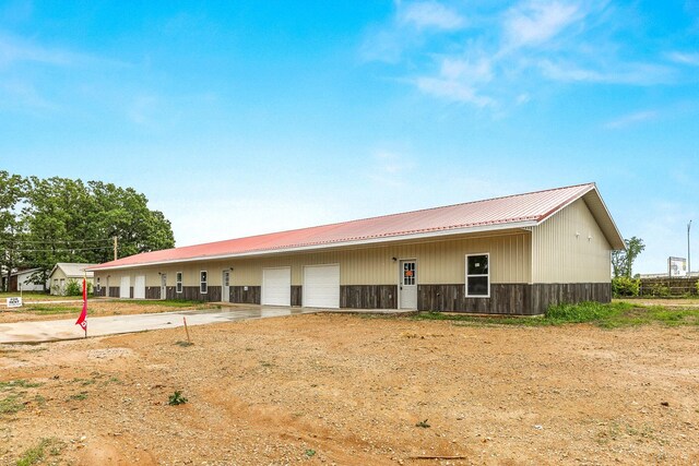 rear view of house with a metal roof and an outdoor structure