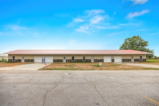 view of front facade featuring a metal roof and concrete driveway