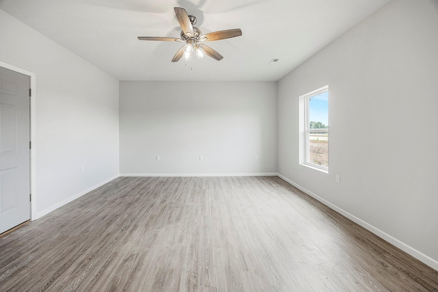 spare room with wood finished floors and a ceiling fan